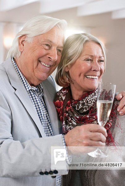 Germany  Wakendorf  Senior couple with sparkling wine  smiling