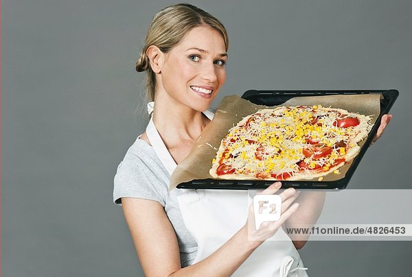 Mittlere erwachsene Frau mit Pizza im Tablett
