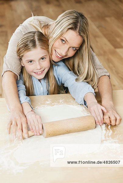 Deutschland    Mutter und Tochter rollenden Teig  lächelnd  Portrait