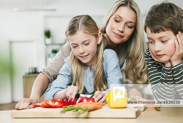 Deutschland    Mutter und Kinder schneiden Gemüse in der Küche