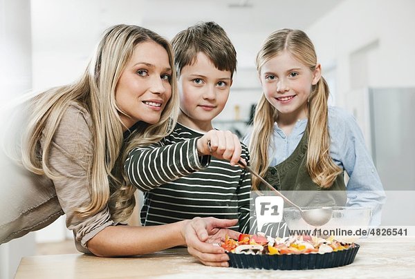 Deutschland    Mutter und Kinder mit Pizza in der Küche