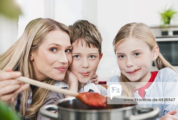 Deutschland    Mutter und Kinder probieren Sauce