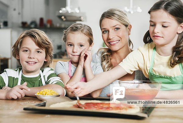 Deutschland    Mutter und Kinder in der Küche machen Pizza