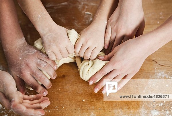 Germany    Mother and children kneading dough