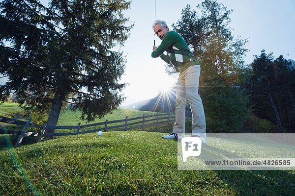 Italien,  Kastelruth,  Reifer Mann beim Golfspielen auf dem Golfplatz