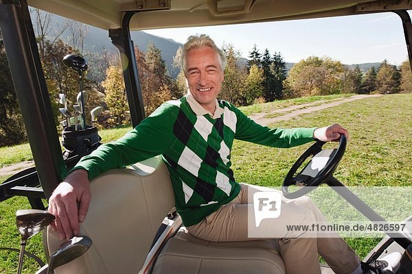 Italien,  Kastelruth,  Reifer Mann im Golfwagen auf dem Golfplatz,  lächelnd,  Portrait
