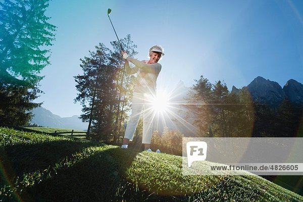 Italien  Kastelruth  Reife Frau beim Golfen auf dem Golfplatz