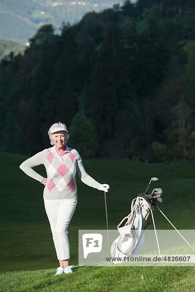 Italien,  Kastelruth,  Reife Frau mit Golftasche auf dem Golfplatz