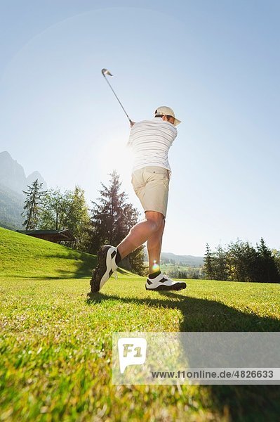 Italien,  Kastelruth,  Mittelerwachsener Mann beim Golfspielen auf dem Golfplatz