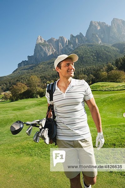 Italy  Kastelruth  Mid adult man walking on golf course