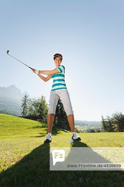 Italien  Kastelruth  Mittlere erwachsene Frau mit Golfschläger auf dem Golfplatz