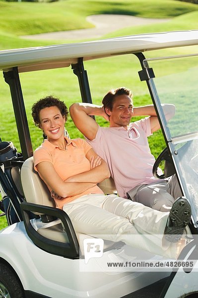 Italien  Kastelruth  Golfer im Golfwagen auf dem Golfplatz  lächelnd  Portrait