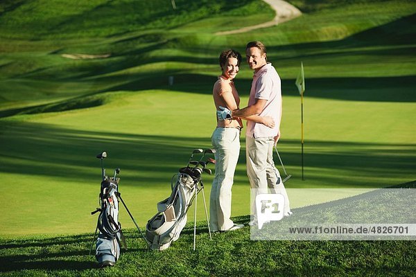 Italien  Kastelruth  Mittleres erwachsenes Paar auf dem Golfplatz  lächelnd  Portrait