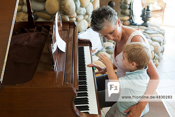 Großmutter und Enkel beim Klavierspielen