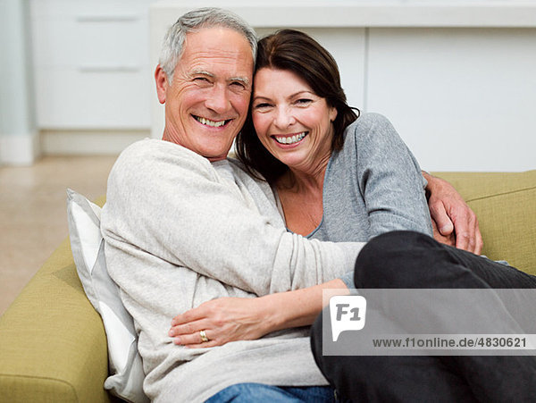 Erwachsenes Paar  das sich auf dem Sofa umarmt