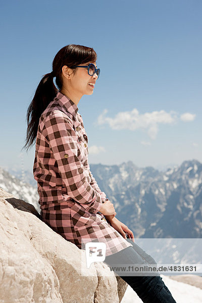Woman sitting on rock on Mount Zugspitze Bavaria Germany