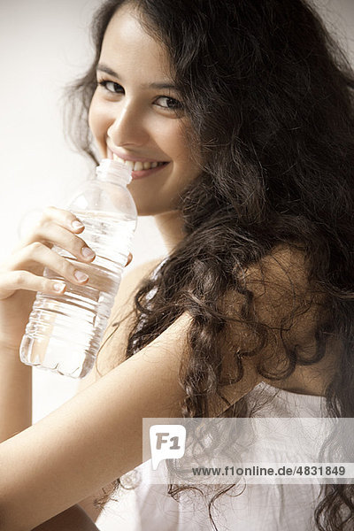 Junge Frau trinkt Wasser  Porträt