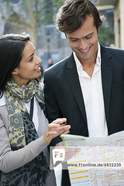 Couple consulting map outdoors