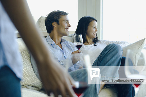 Couple enjoying red wine on sofa
