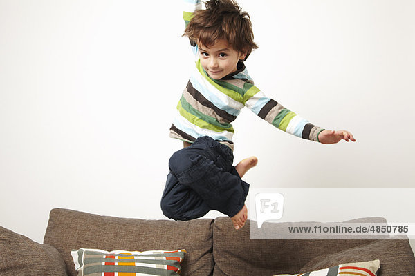 Kleiner Junge springt auf Sofa