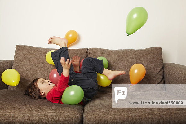 liegend  liegen  liegt  liegendes  liegender  liegende  daliegen  Couch  Junge - Person  Luftballon  Ballon  treten  jung