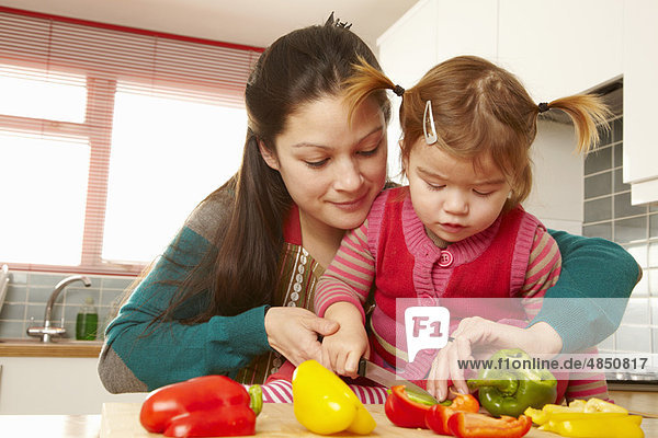 Mutter und Tochter beim Gemüsehacken