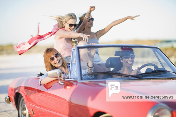 Mädchen mit rotem Schal fahren im Cabriolet