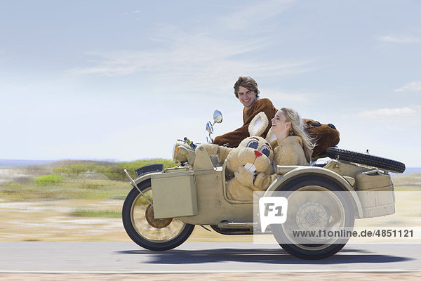 Verkleidetes Paar auf dem Motorrad