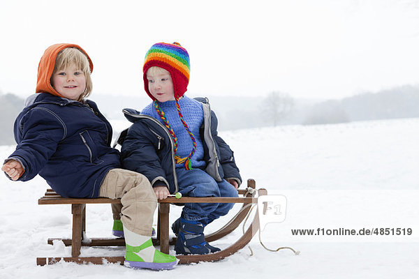 Two boys on a sledge in the snow