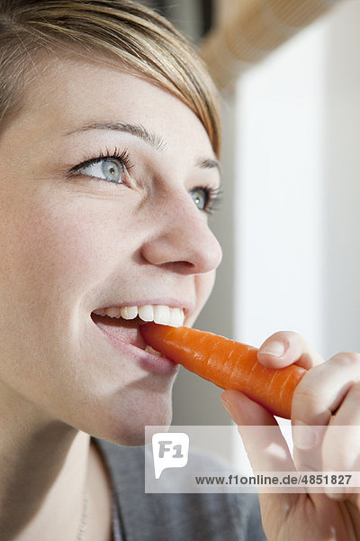 Woman eating a carrot