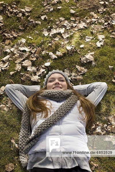 Young woman lying in leaves