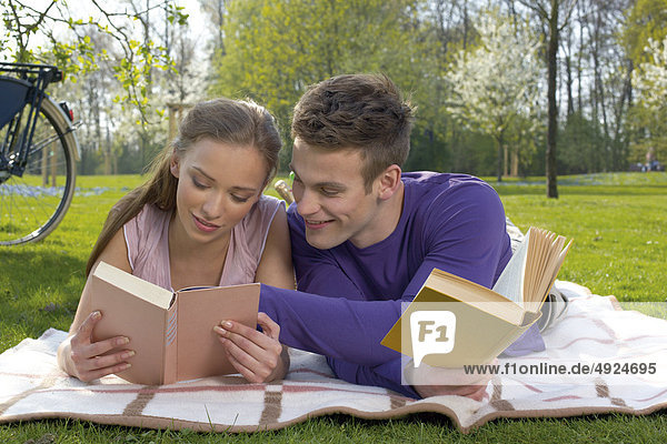 Young couple reading on a meadow