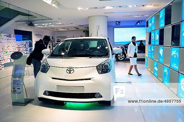 Paris  France  Man Shopping in New Car Showroom  Toyota Car  IQ  Hybrid Engine