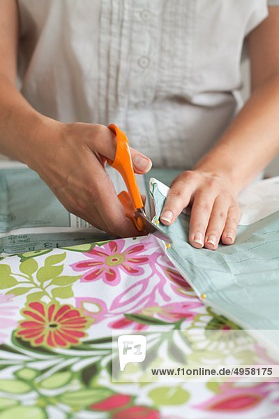 Frau schneiden Tuch mit nähen Muster