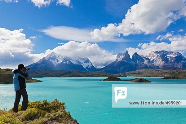 Südamerika  Chile  Patagonien  Fotografin  die ein Bild von den torres del paine Bergen aufnimmt.