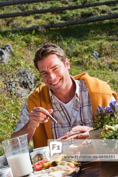 Österreich  Salzburger Land  Filzmoos  Mann beim Snacken  lächelnd  Portrait