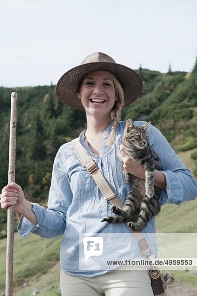 Austria,  Salzburg Country,  Filzmoos,  Young woman with cat,  smiling,  portrait