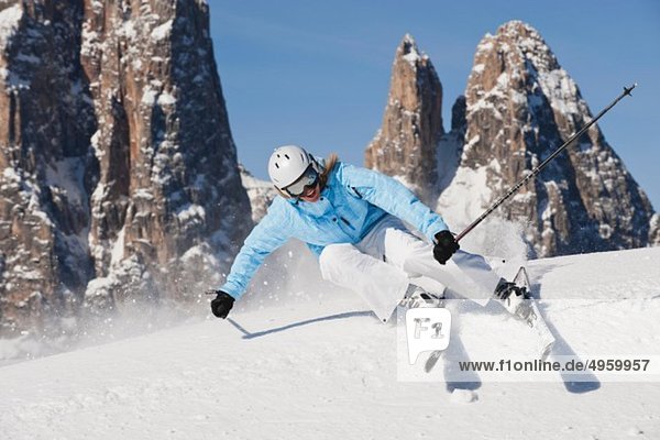 Italy  Trentino-Alto Adige  Alto Adige  Bolzano  Seiser Alm  Young woman skiing near mountain