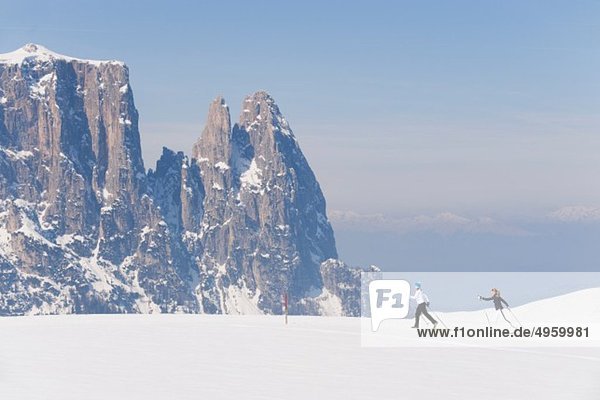 Italy  Trentino-Alto Adige  Alto Adige  Bolzano  Seiser Alm  Two women doing cross-country skiing near mountain