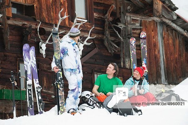 Österreich  Kleinwalsertal  Freunde sitzend bei der Berghütte