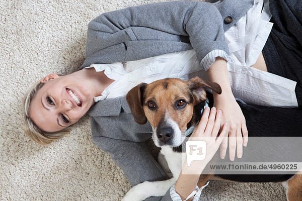 Junge Frau spielt mit Hund  lächelnd