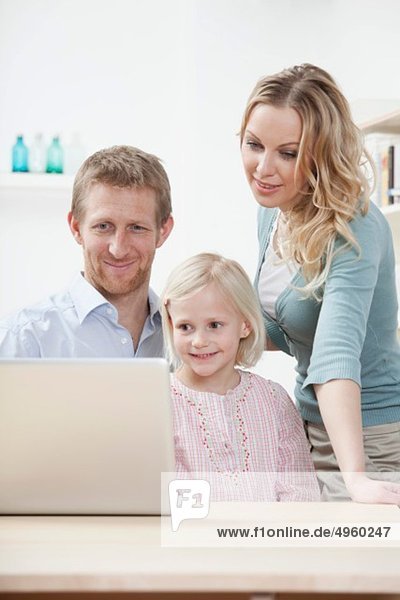 Germany  Bavaria  Munich  Family using laptop  smiling
