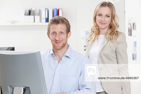 Businesswoman and businessman in office  smiling  portrait