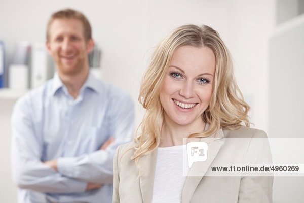 Businesswoman and businessman in office  smiling