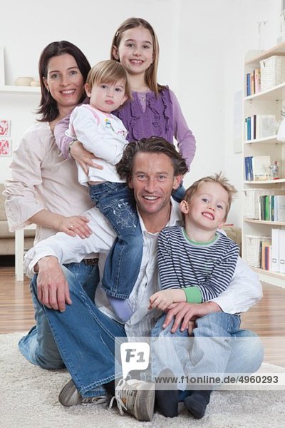 Germany  Bavaria  Munich  Family sitting togetherness on floor  smiling  portrait