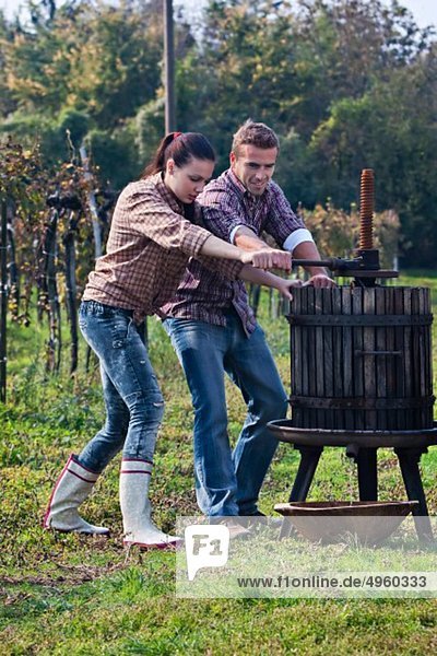 Croatia  Aljmas  Young man and woman making wine in vineyard