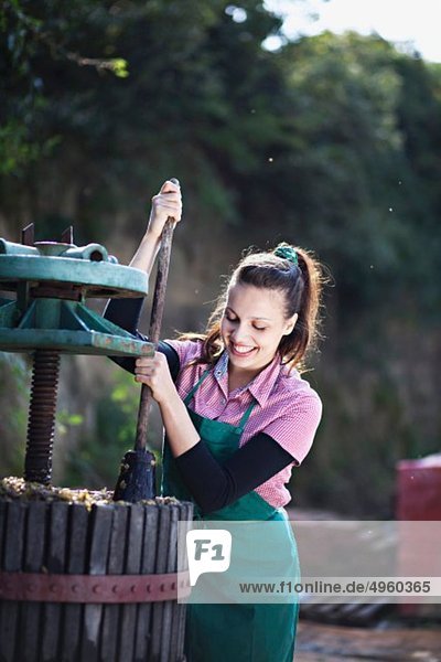 Kroatien  Baranja  Junge Frau beim Traubenpressen