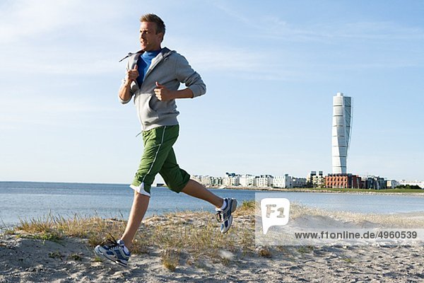 A man jogging on the beach  Malmo  Sweden.