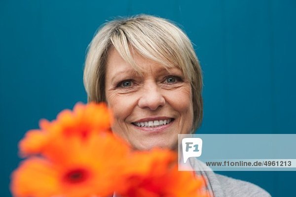 Seniorin mit Blumenstrauß  lächelnd