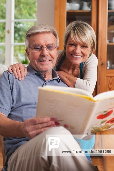 Deutschland  Kratzeburg  Seniorenpaar liest Kochbuch
